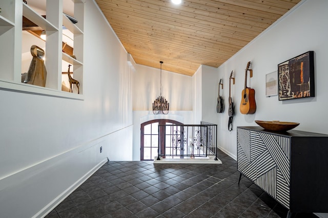 corridor with a notable chandelier, lofted ceiling, wood ceiling, crown molding, and dark tile patterned floors