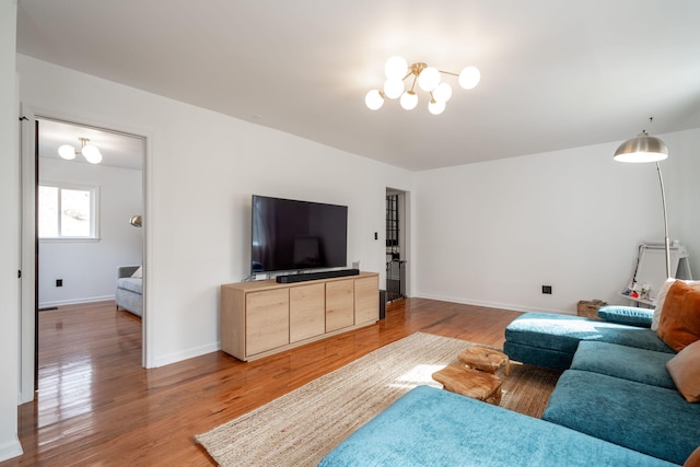 living room featuring an inviting chandelier and hardwood / wood-style floors