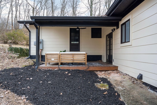 view of exterior entry with ceiling fan and a porch