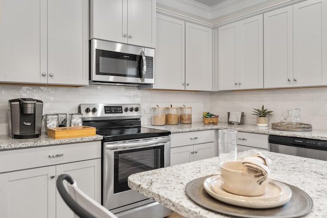 kitchen featuring white cabinetry, light stone counters, decorative backsplash, and stainless steel appliances