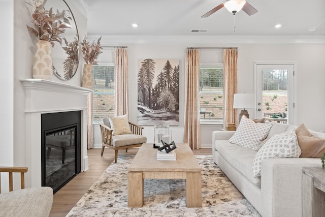 interior space with crown molding, ceiling fan, and light hardwood / wood-style flooring