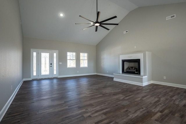 unfurnished living room with ceiling fan, dark hardwood / wood-style floors, and high vaulted ceiling