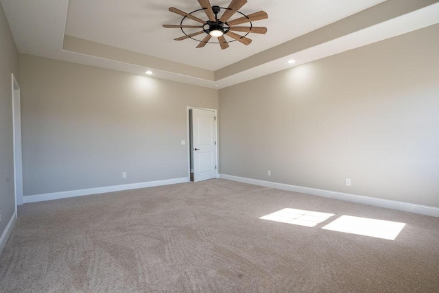 unfurnished room with light carpet, a raised ceiling, and ceiling fan