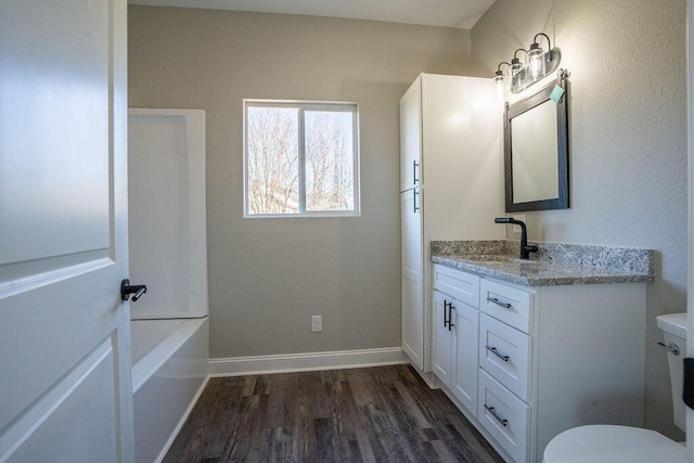 bathroom with vanity, toilet, and wood-type flooring