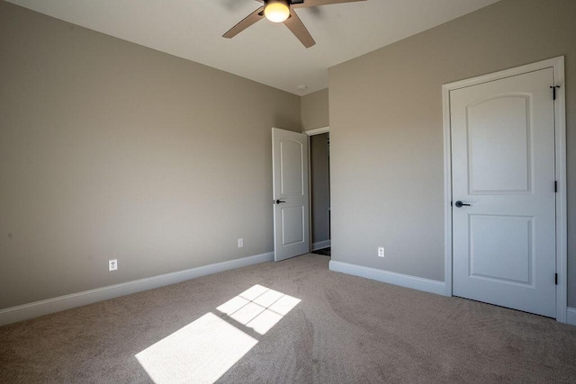 unfurnished bedroom with ceiling fan and light colored carpet