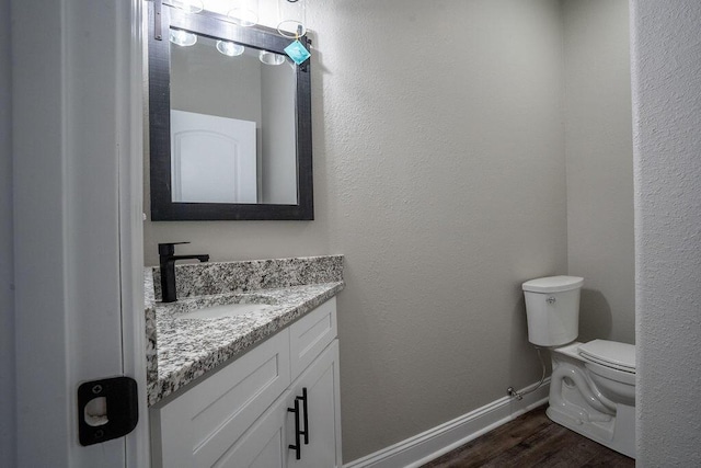 bathroom featuring vanity, toilet, and hardwood / wood-style floors