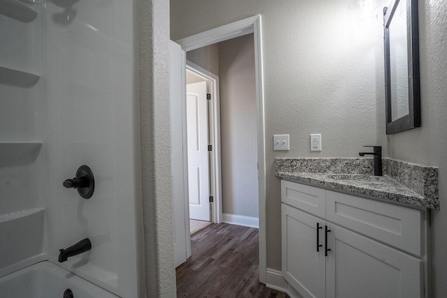 bathroom with vanity, hardwood / wood-style floors, and shower / bathing tub combination