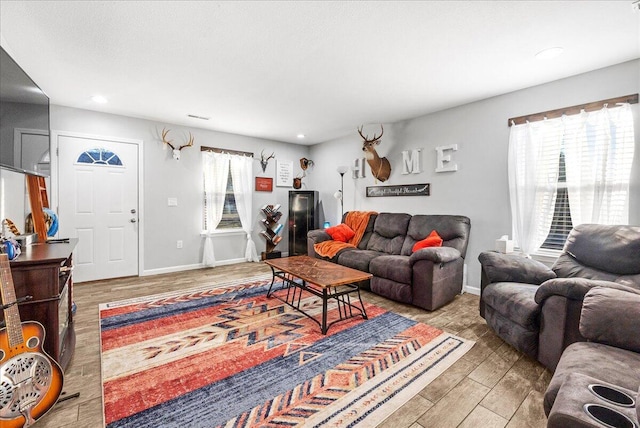 living room with light hardwood / wood-style floors and a healthy amount of sunlight