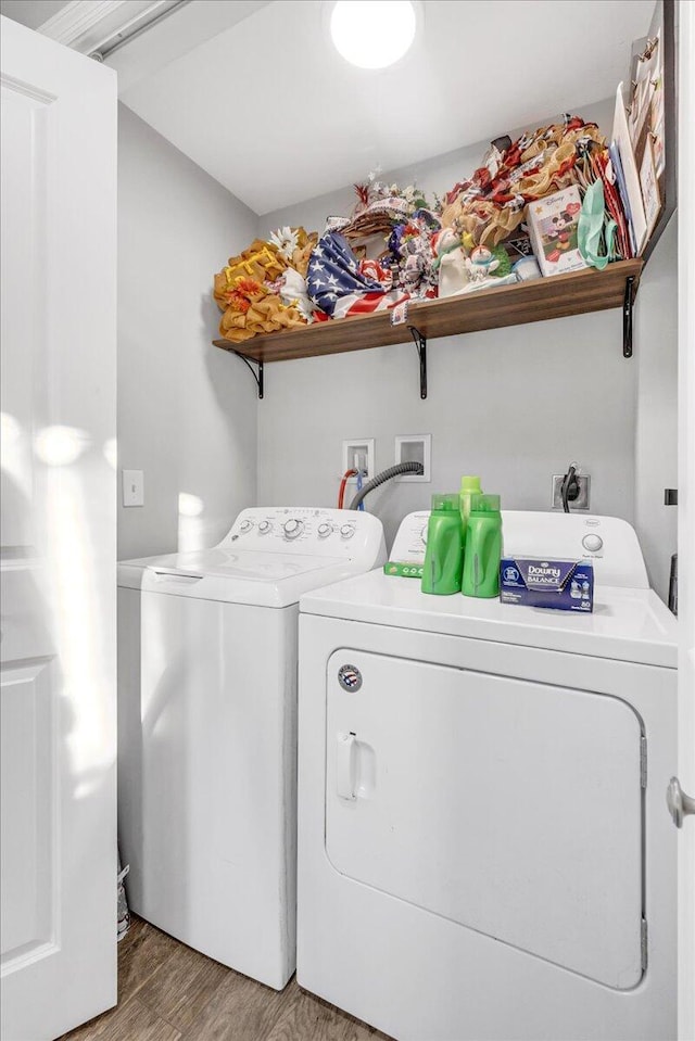 laundry area with separate washer and dryer and hardwood / wood-style floors