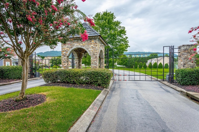 exterior space featuring a gate, a gated entry, and curbs