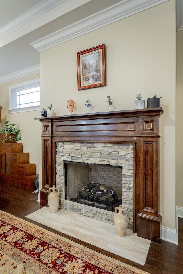 details with baseboards, a stone fireplace, wood finished floors, and crown molding