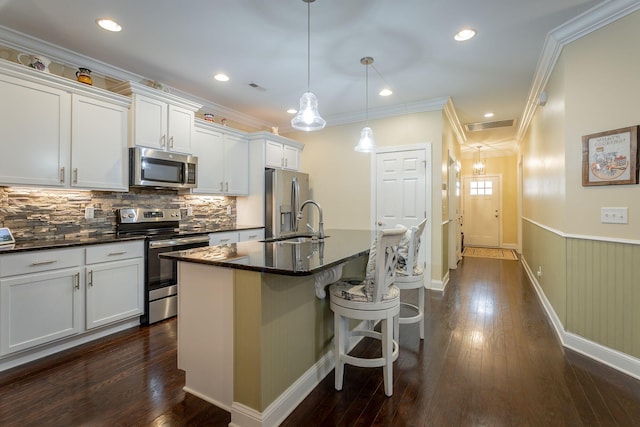 kitchen with stainless steel appliances, dark wood-style flooring, a sink, and a kitchen island with sink