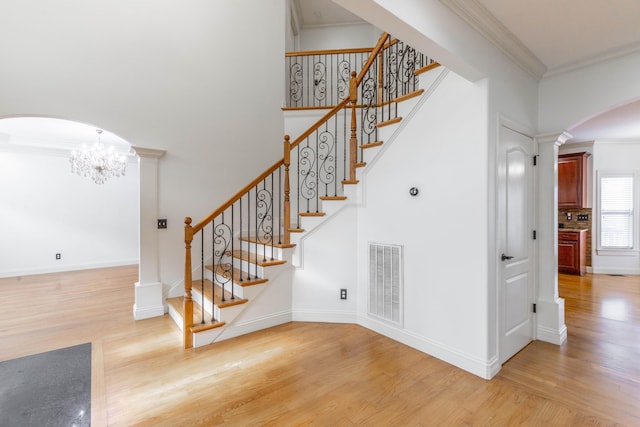 stairs featuring a high ceiling, crown molding, and hardwood / wood-style floors