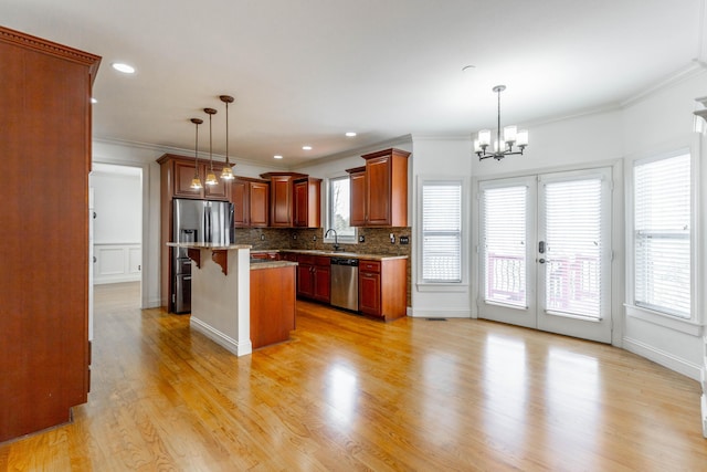 kitchen with appliances with stainless steel finishes, a kitchen breakfast bar, a center island, and decorative light fixtures