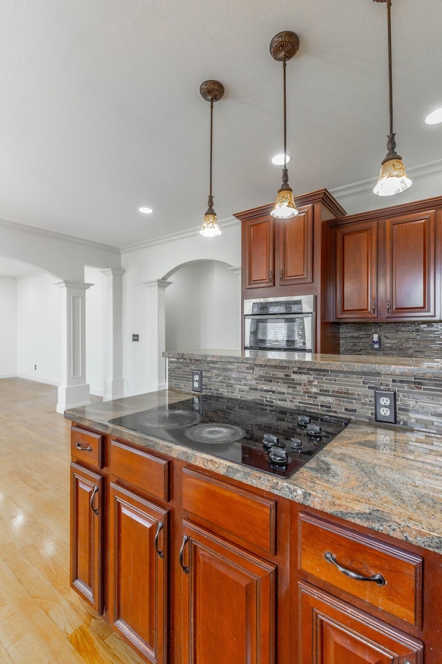 kitchen featuring pendant lighting, black electric stovetop, decorative backsplash, and oven