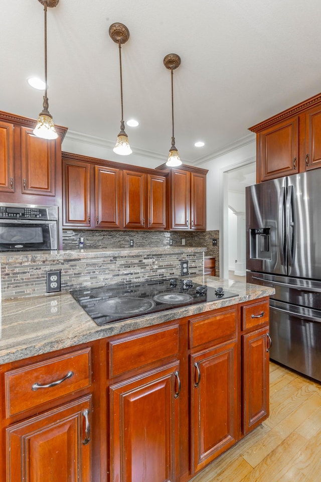 kitchen with light stone counters, hanging light fixtures, tasteful backsplash, and appliances with stainless steel finishes