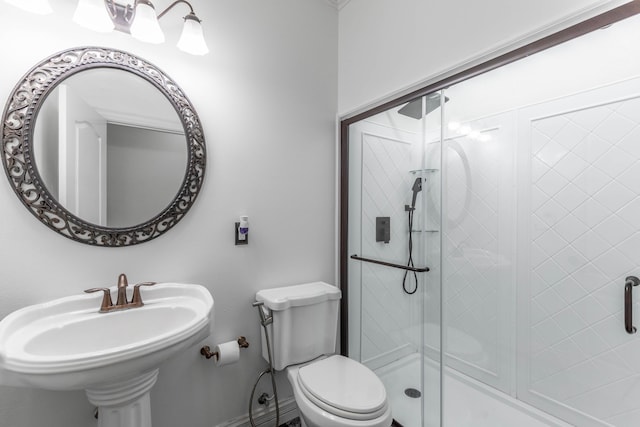 bathroom featuring an enclosed shower, sink, and toilet