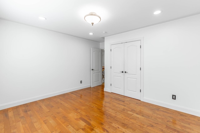 unfurnished bedroom featuring wood-type flooring and a closet