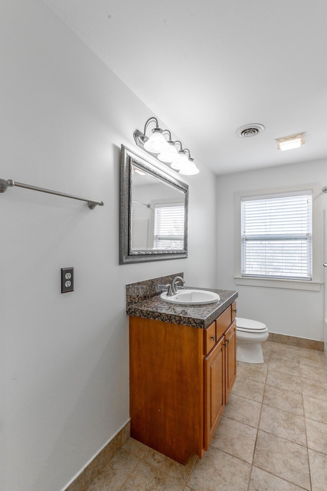 bathroom with tile patterned flooring, vanity, and toilet