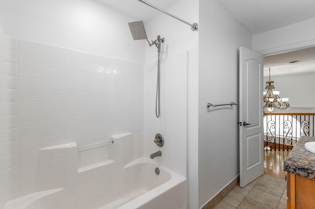 bathroom featuring tile patterned flooring, vanity, tub / shower combination, and a notable chandelier