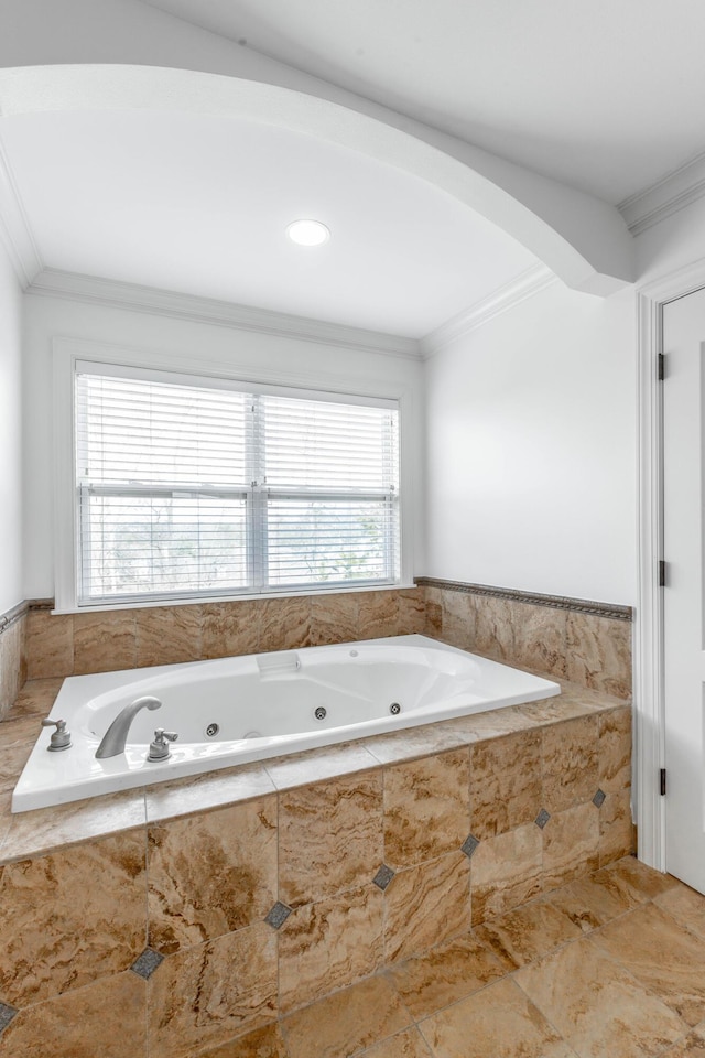 bathroom with crown molding and tiled tub