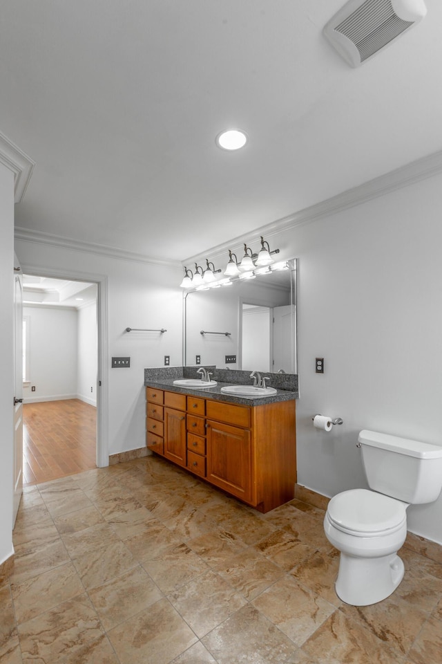 bathroom featuring crown molding, vanity, and toilet