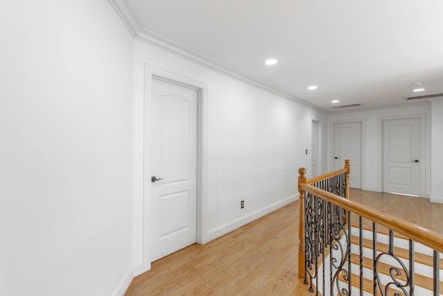 corridor featuring crown molding and light hardwood / wood-style floors