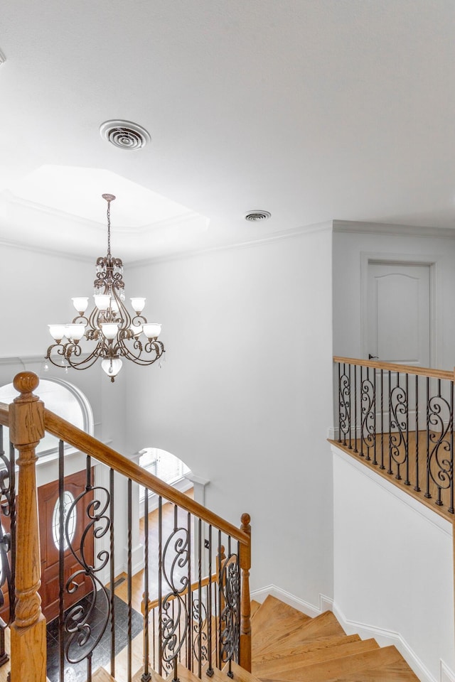 stairs with a notable chandelier and hardwood / wood-style flooring