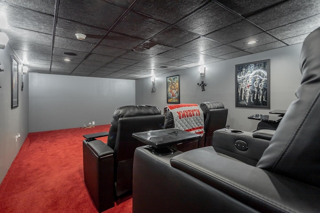 cinema room with a paneled ceiling and carpet flooring