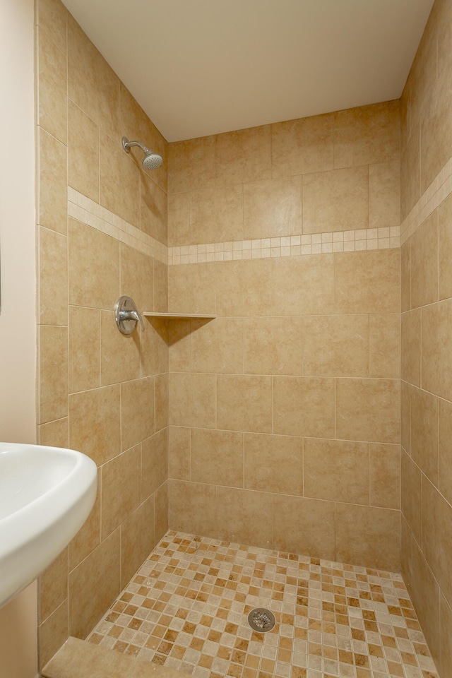 bathroom featuring tiled shower and sink