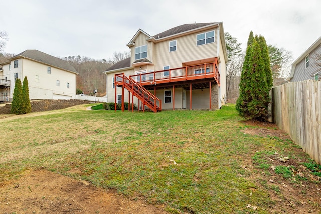 rear view of property featuring a deck and a lawn