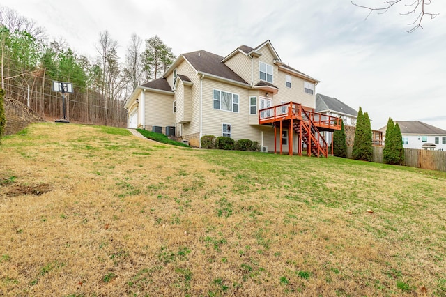 back of property with a wooden deck and a yard