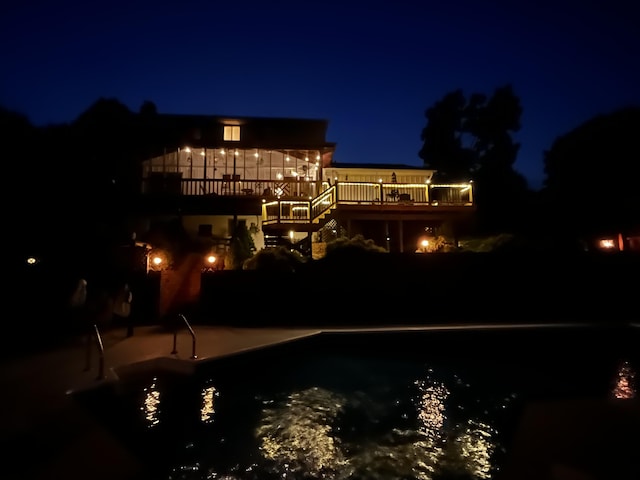 back house at twilight featuring a patio and a deck