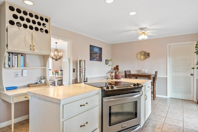 kitchen featuring light tile patterned floors, white cabinetry, ornamental molding, ceiling fan with notable chandelier, and stainless steel range with electric cooktop