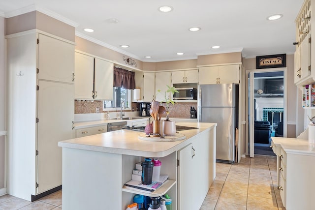 kitchen featuring decorative backsplash, a kitchen island, light tile patterned flooring, and appliances with stainless steel finishes