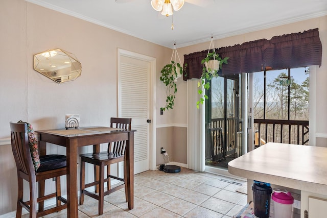 tiled dining area featuring crown molding and ceiling fan