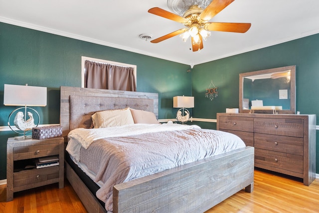 bedroom with crown molding, ceiling fan, and light hardwood / wood-style flooring