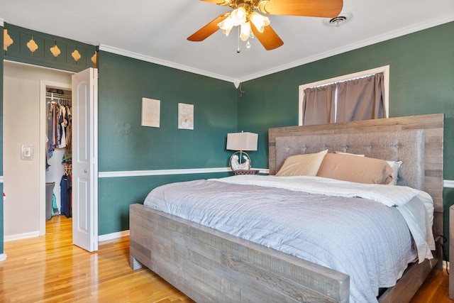 bedroom with hardwood / wood-style flooring, ceiling fan, and crown molding