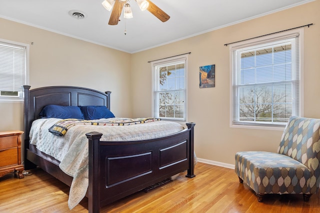 bedroom with ornamental molding, ceiling fan, and light wood-type flooring