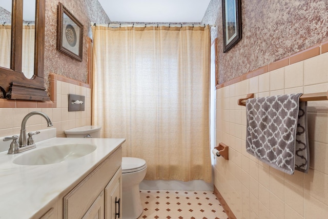 full bathroom with vanity, tile walls, shower / bathtub combination with curtain, and toilet