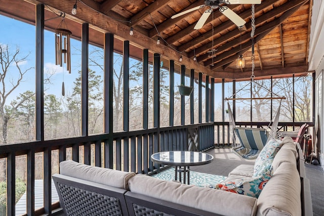 sunroom featuring a healthy amount of sunlight, lofted ceiling with beams, and wooden ceiling