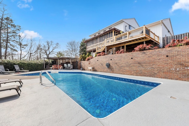 view of swimming pool featuring a wooden deck and a patio