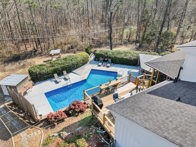 view of pool featuring a wooden deck and a patio