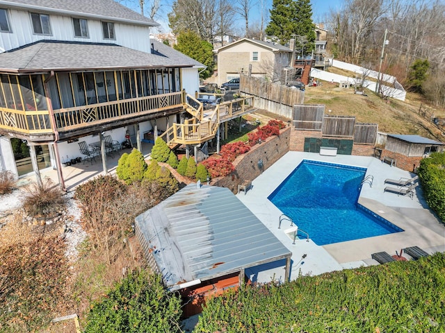 view of pool with a deck and a sunroom