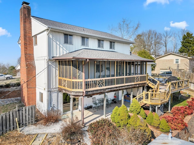 rear view of property featuring a patio, a sunroom, and a wooden deck