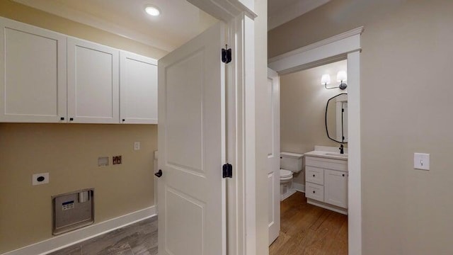 laundry room featuring sink, cabinets, hookup for a washing machine, dark wood-type flooring, and hookup for an electric dryer