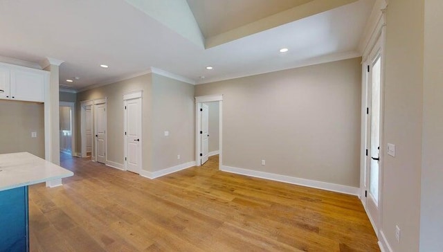 spare room featuring crown molding and light wood-type flooring