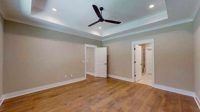 unfurnished bedroom featuring crown molding, ceiling fan, connected bathroom, light hardwood / wood-style floors, and a raised ceiling