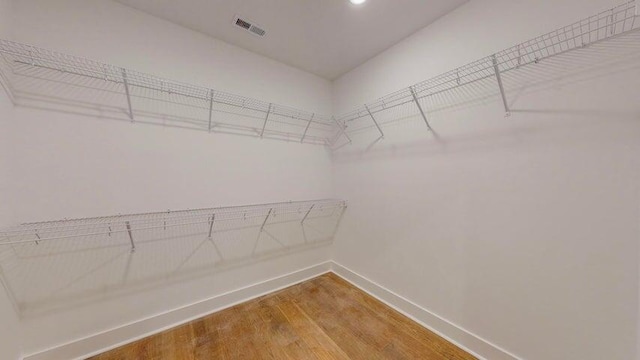 walk in closet with wood-type flooring