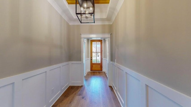 entryway with ornamental molding, an inviting chandelier, light hardwood / wood-style floors, and a tray ceiling